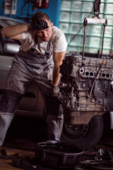 Obraz na płótnie Canvas Tired car mechanic at work