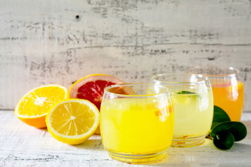 Citrus juices with fresh fruit on wooden table