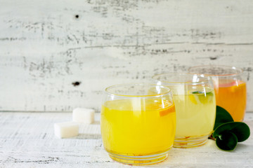Fresh citrus juices on a white wooden table