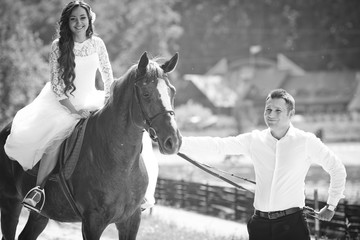 Obraz premium stylish gorgeous happy brunette bride on the horse and elegant g