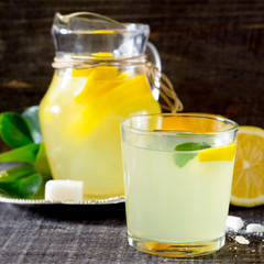 A drink with fresh lemon on a wooden table