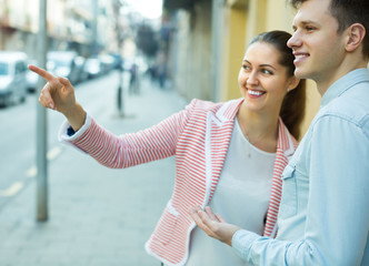 Girl helping lost male tourist .