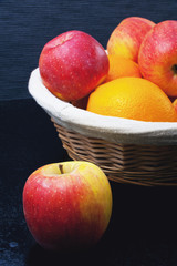 Basket with apples and oranges on a blue background