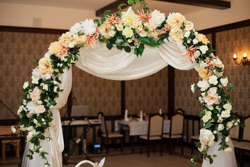 stylish decorated arch with flowers at the reception in a restau