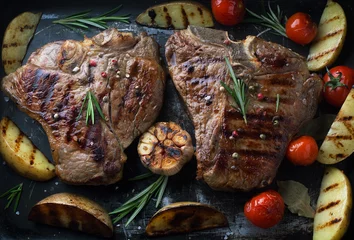 Keuken spatwand met foto Grilled meat T-Bone steak with spices, rosemary and vegetables © Belokoni Dmitri