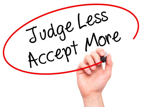 Man Hand writing Judge Less Accept More with black marker on vis