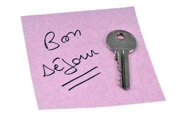 Bon séjour écrit sur une feuille avec une clé