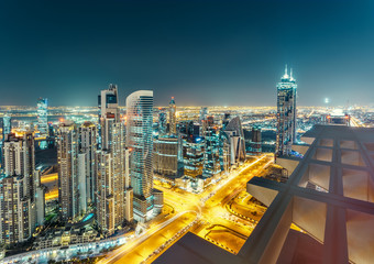 Fototapeta na wymiar Scenic view from rooftop of Dubai's business bay architecture by night with residential buildings.