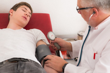 junger mann bekommt den blutdruck gemessen