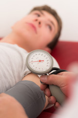 teenager bei der blutdruckmessung
