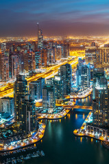 Fototapeta premium Fantastic rooftop skyline: illuminated architecture of a big city. Dubai Marina by night, United Arab Emirates.