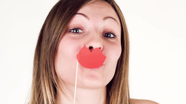 Beautiful girl hamming with lips on a stick.