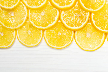Sliced lemons on white wooden surface, top view