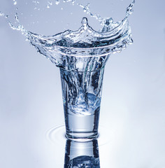 icecube splashing into a glass of water