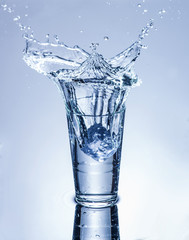 icecube splashing into a glass of water