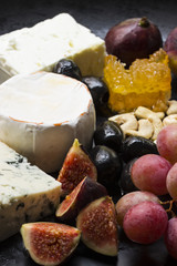 Käseplatte mit Trauben, Feigen, Oliven, Nüssen und Honig