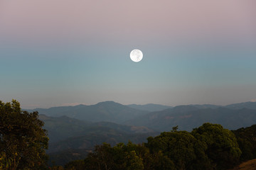 View of full moon over mountain range at sunset, mountain gap, mountain layer