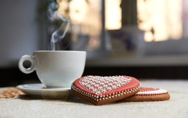 You are special. Gingerbread glazed cookies and a cup of steaming drink on the table