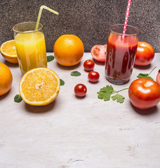Healthy foods fresh juice in glasses with straws, oranges and tomatoes on wooden rustic background top view close up