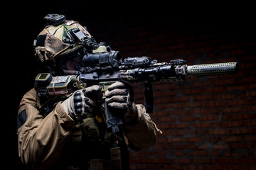 Spec ops soldier in uniform with assault rifle/man in military uniform with assault rifle aiming at...