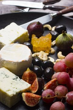 Käseplatte mit Trauben, Feigen, Oliven, Nüssen und Honig