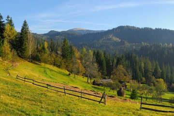 Fototapeta na wymiar Mountain landscape with barn and haystack.