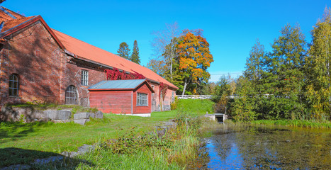 Old red brick building over pond © Igor Groshev