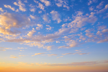 Naklejka na ściany i meble Sunset sky with golden and blue clouds