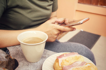 Hot coffee with smart phone and croissant