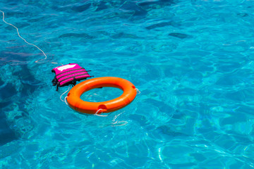 Lifebuoy and lifejacket in a stormy blue sea.