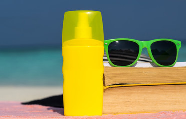 Sunscreen, hat and sunglasses on tropical beach