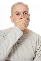 Portrait of a old man covering his mouth over white background