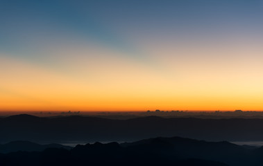 Obraz premium Dramatic sunset and sunrise sky and mountain layer.