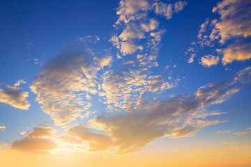 Obraz na płótnie Canvas Sunset sky with golden and blue clouds