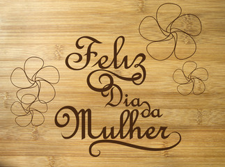 Feliz dia da Mulher. Happy Woman's day in portuguese language on wood background.