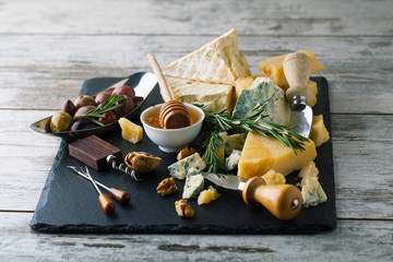 Delicious cheeses on a board with honey, nuts on a white backgro