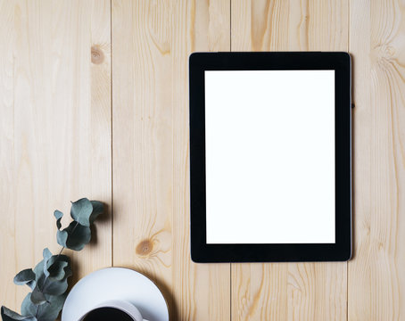 Tablet with a clean blank screen monitor with cup of coffee on a wooden background with natural wood planks top view horizontal, computer for your information