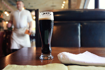 glass of dark beer in a restaurant interior