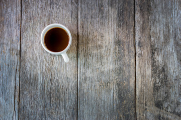 Black coffee in white Ceramic Cup on old wooden table.