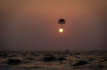 A couple parasailing during sunset in the Indian city of Goa