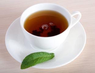 Teacup and  a leaf  of mint