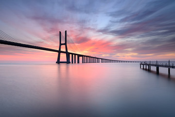 Fototapeta na wymiar Lisboa ao Nascer do Sol com a fantástica Ponte Vasco da Gama.