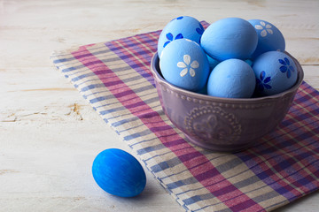 Blue Easter eggs in a purple bowl