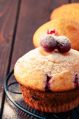 Cranberry muffins on wooden background.