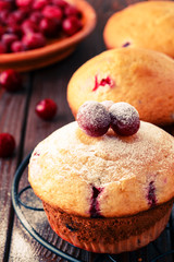 Cranberry muffins on wooden background.