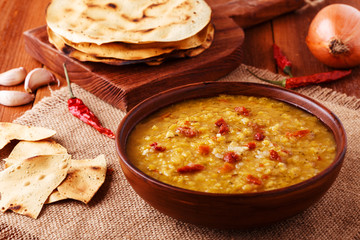 .Thick indian red lentil soup with cilantro served with indian f