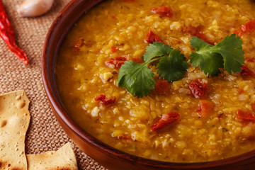 .Thick indian red lentil soup with cilantro served with indian f