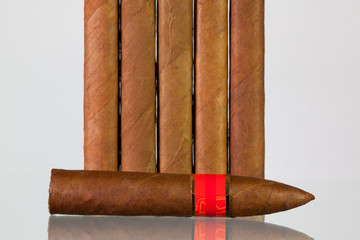 Different cigars on a  glass desk