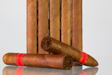 Different cigars on a  glass desk