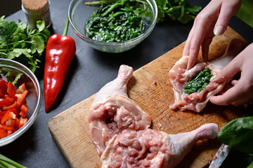 Young woman preparing chicken with vegetables